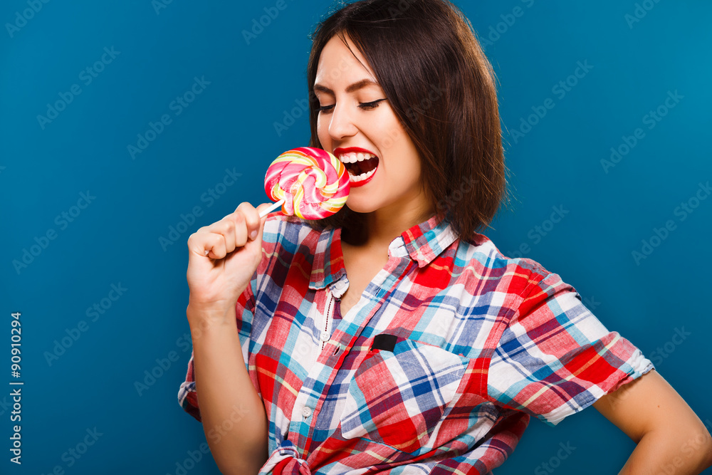 Obraz premium Nice brunette woman is going to eat big colored candy