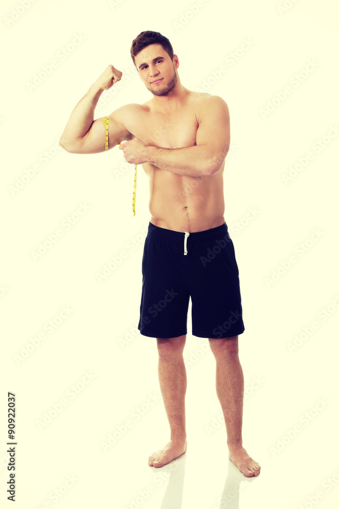 Muscular man measuring his biceps.