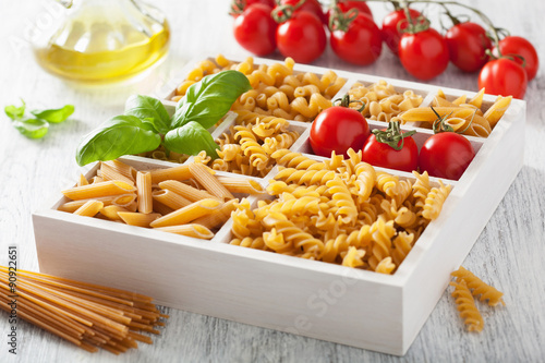 various raw wholegrain pasta in white wooden box photo