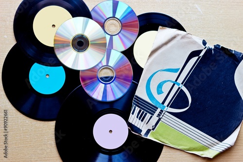 Vinyl record discs ans CD on wooden background. Top view