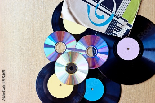 Vinyl record discs ans CD on wooden background. Top view
