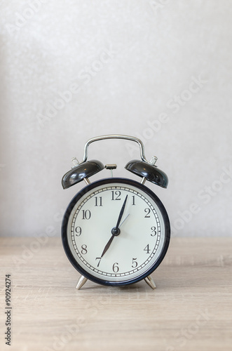 modern black alarm clock on wooden table