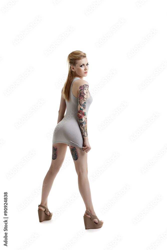 Cute tattooed model posing in vest and wedges Cute tattooed model posing in vest and wedges
