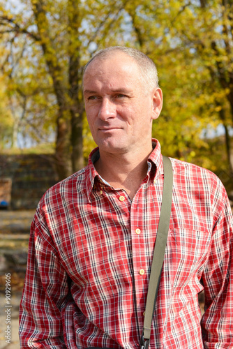 Portrait of a serious man in a plaid shirt on the background of