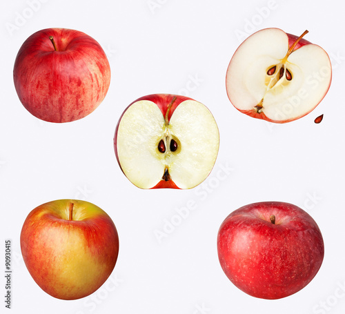 Three whole apples and two halved apples isolated on white