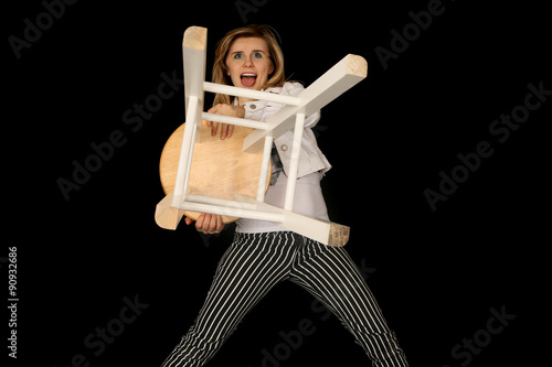 crazy blond woman holding a bar stool out like a lion trainer