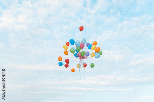 A bunch of colorful balloons flying in the sky