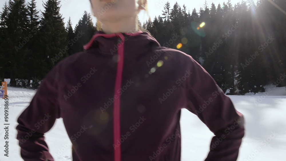 young athlete woman relaxing after jogging on snow