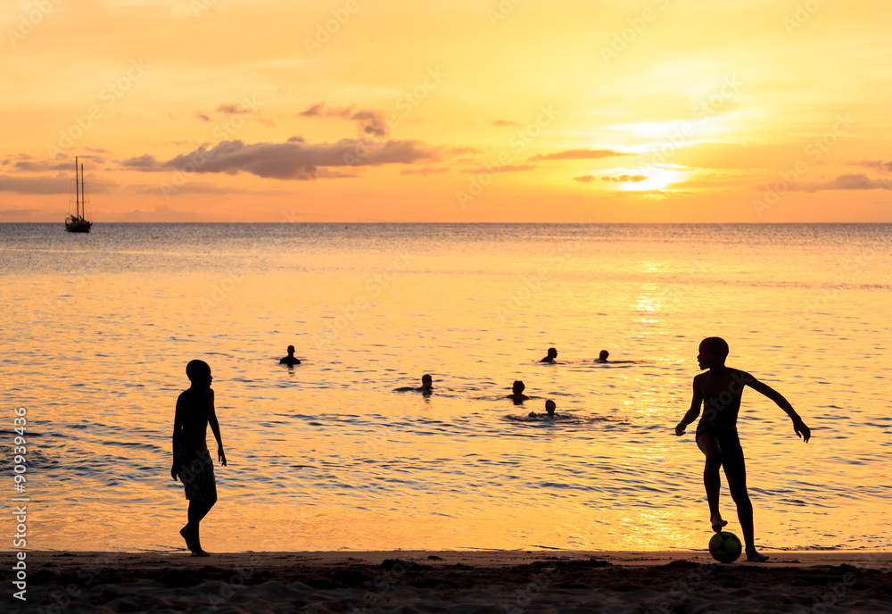 Fototapeta premium Childrens silhouette playing soccer on sunset at Tarrafal beach