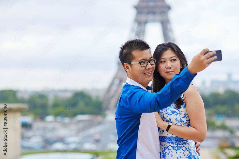 Naklejka premium Beautiful Asian couple taking selfie in Paris