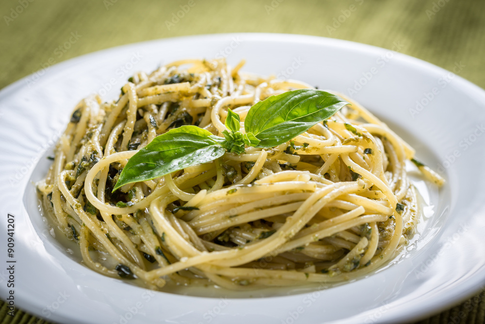 Portion of pasta with pesto sauce and basil leaf Portion of pasta with pesto sauce and basil leaf
