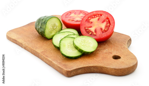 Tomato and cucumber on the board.