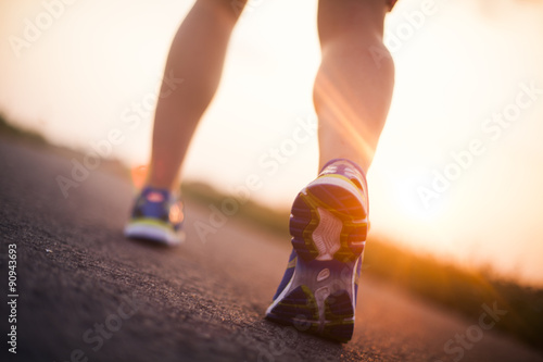 Runner feet running on road closeup on shoe