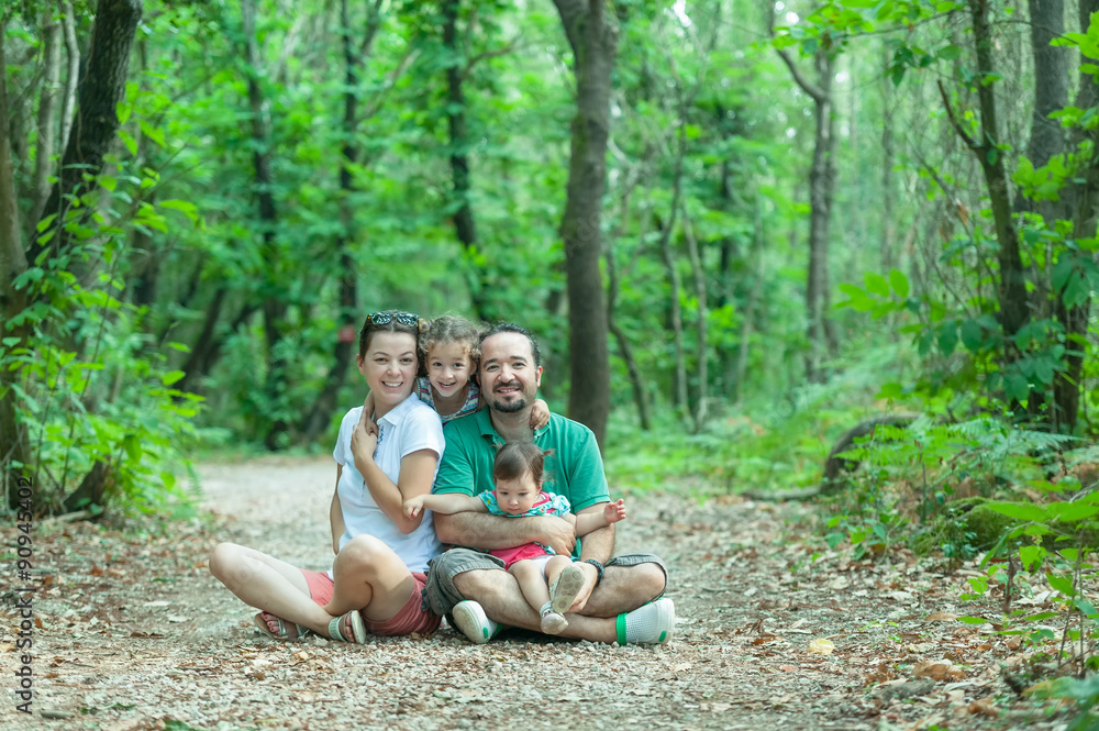 Beautiful happy family enjoying in the forest park
