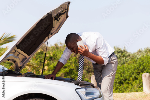 Fotografi young man with broken down car calling for help