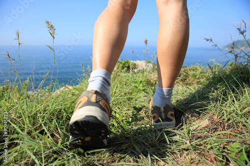hiking legs walking on seaside mountain peak