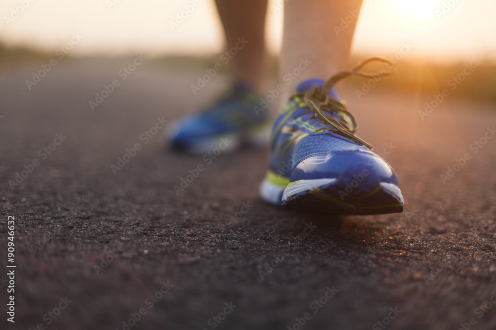 Runner feet running on road closeup on shoe