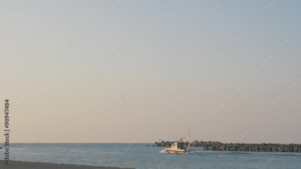 夕暮れの海と出航するボート