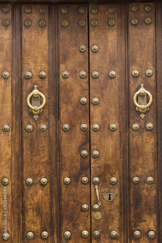 Puerta rústica de madera con adornos dorados.