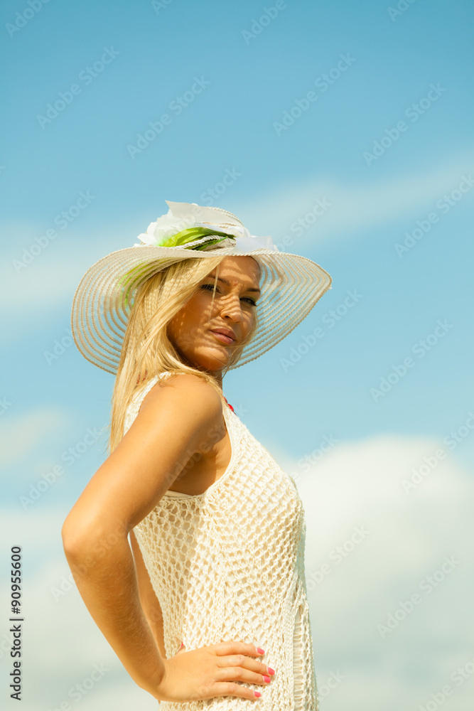 Beautiful blonde girl in hat on sky background