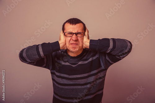 European-looking male covering his ears with his hands brunet re