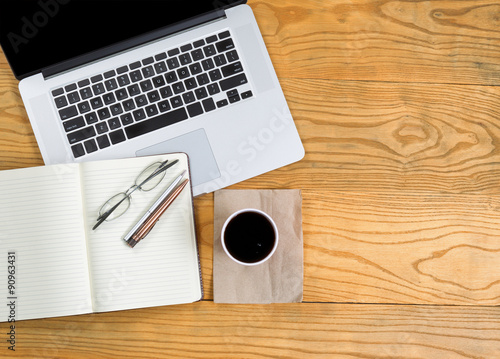 Computer with writing tools and dark coffee on top of desktop