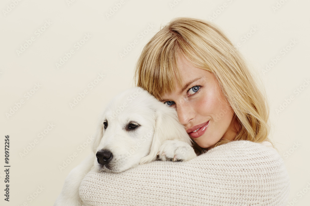 Young woman embracing pet puppy, portrait Young woman embracing pet puppy, portrait