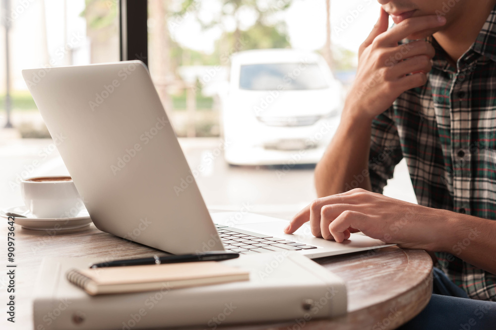 Businessman using laptop with tablet and pen on wooden table in Businessman using laptop with tablet and pen on wooden table in