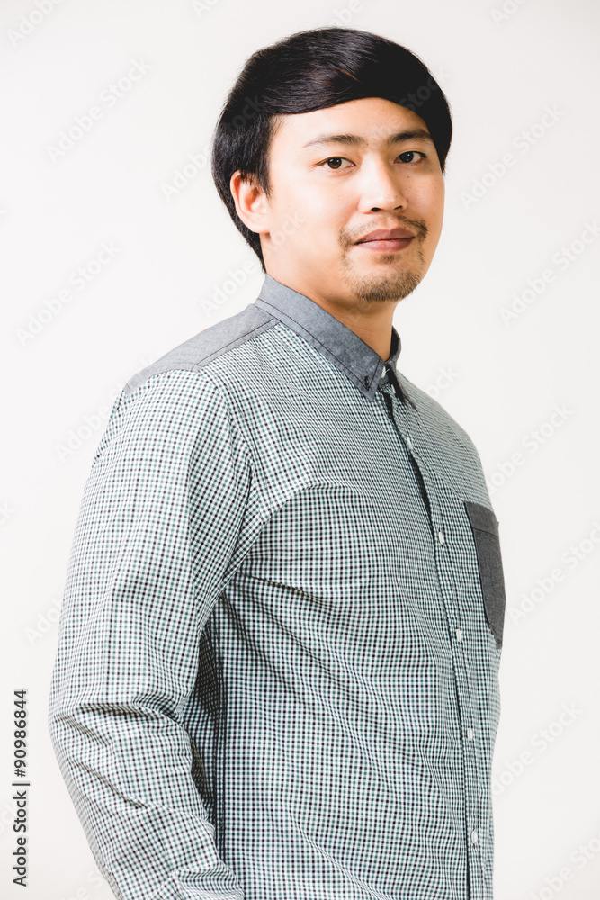 Young confident hipster man with beard posing on the white backg Young confident hipster man with beard posing on the white backg