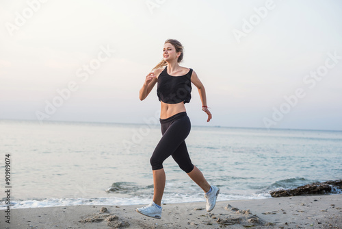 Running woman. Female runner jogging during the sunrise on beach.
