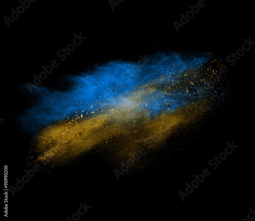 Blue and yellow powder explosion isolated on black 