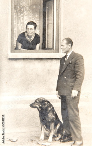 Old photo depicting senior couple and dog