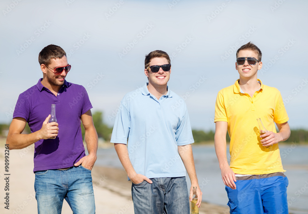 happy friends drinking beer and walking on beach happy friends drinking beer and walking on beach