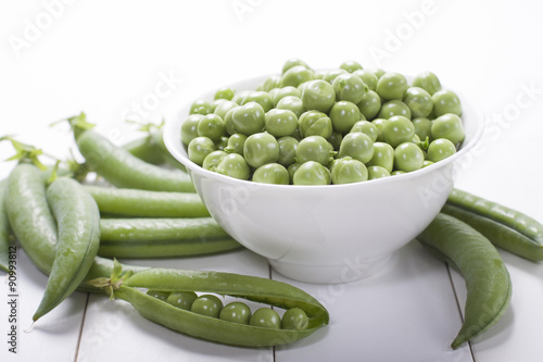 Fresh green peas in a white bowl  .