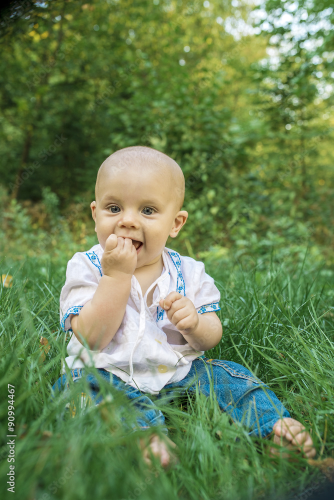 happy, smiling baby on the green grass in the park