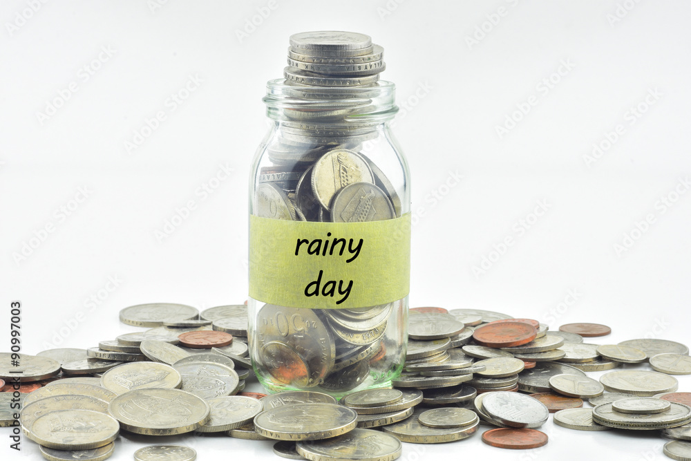 Isolated coins in jar with rainy day label - financial concept Isolated coins in jar with rainy day label - financial concept