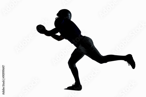 Silhouette American football player catching ball