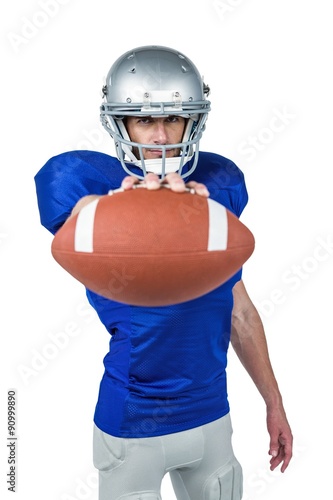 Portrait of American football player showing ball