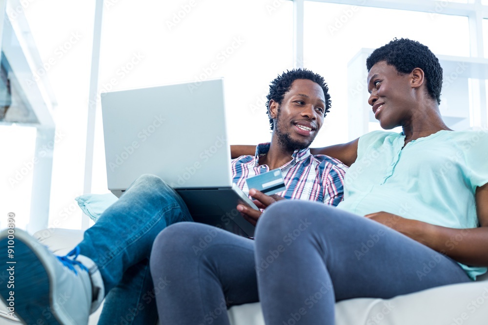 Couple smiling and sitting on sofa 
