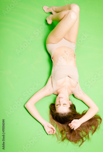 Upside down view of pretty woman in beige jumpsuit lying