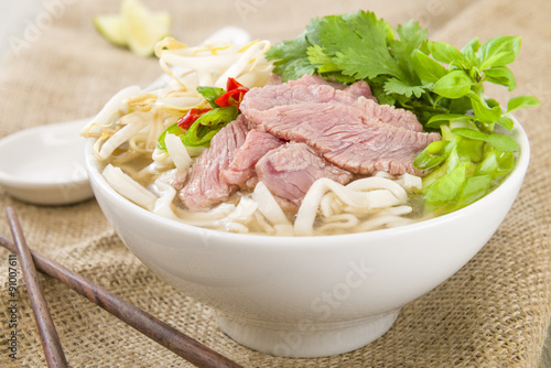 Pho Bo - Vietnamese fresh rice noodle soup with beef, herbs and chili. Vietnam's national dish.

