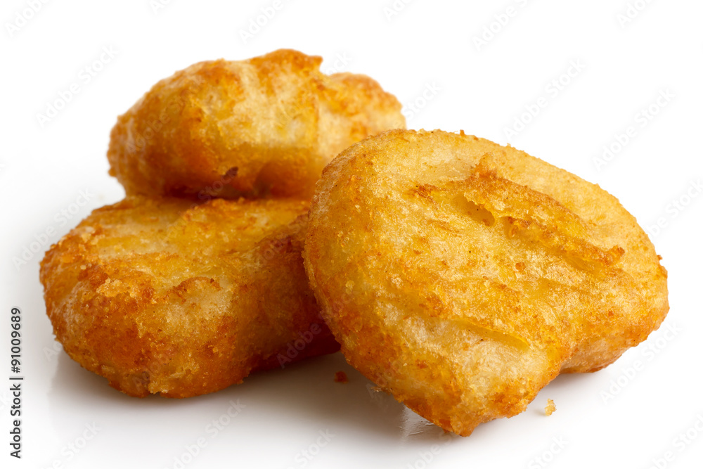 Three golden deep-fried battered chicken nuggets isolated on whi