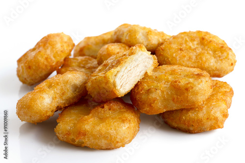 Pile of golden deep-fried battered chicken nuggets isolated on w