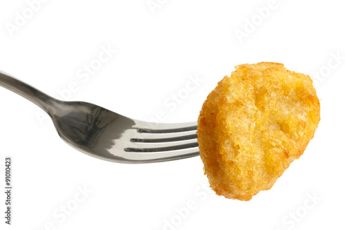 Single golden deep-fried battered chicken nugget on a fork isola