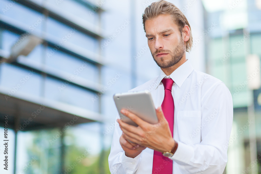 Blonde businessman using a tablet pc