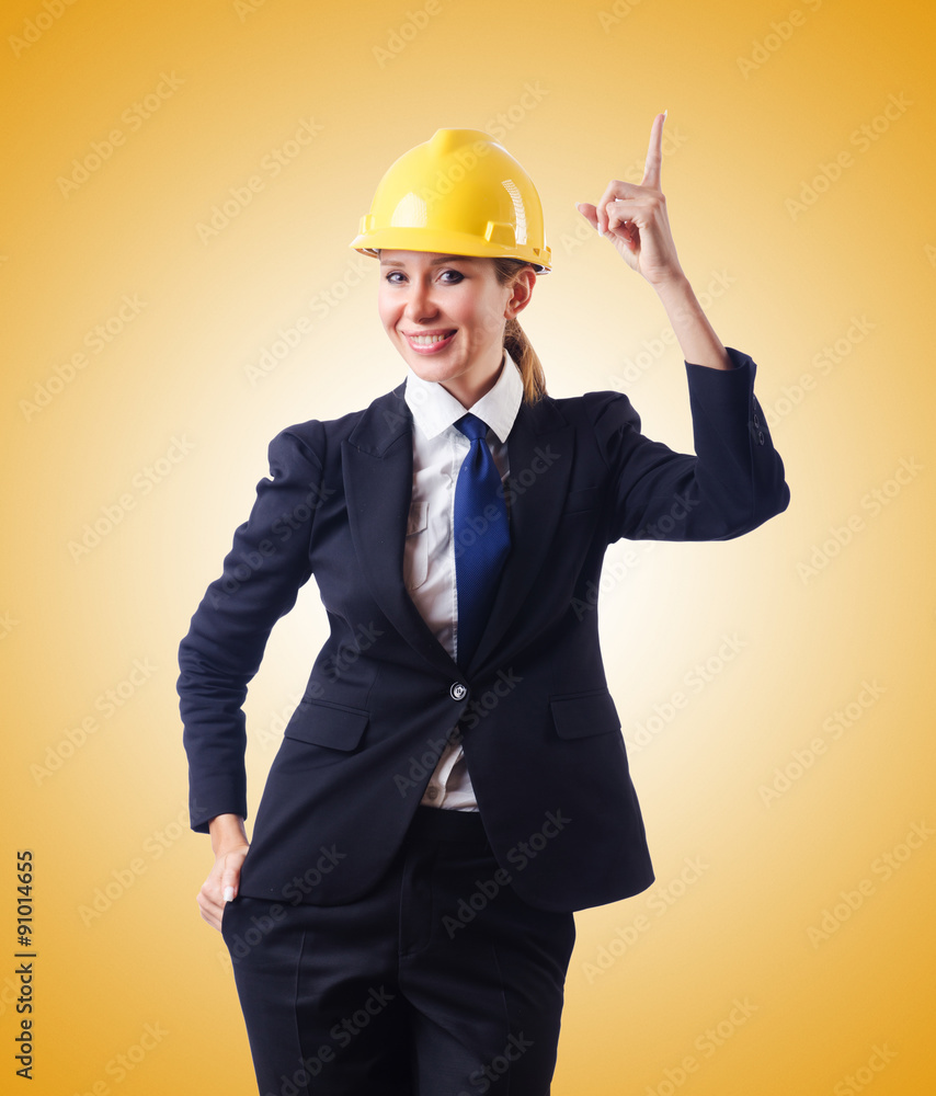 Young businesswoman with hard hat against gradient Young businesswoman with hard hat against gradient