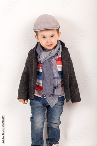 fashionable little boy with hat and scarf, wearing a jacket. Stylish kid. Fashion children
