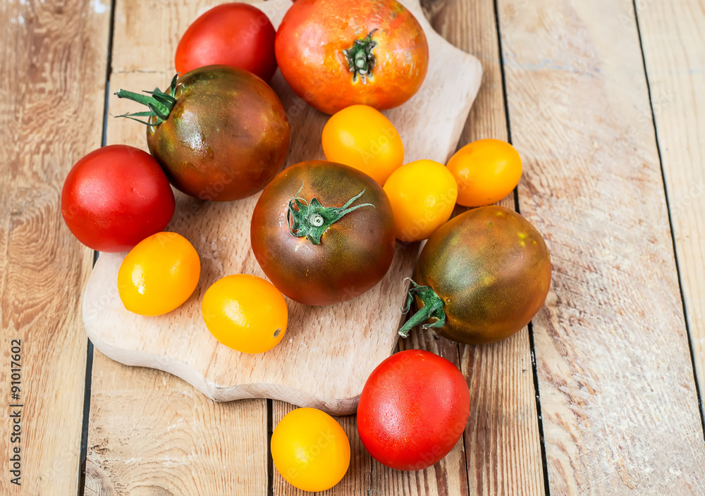 Colorful  tomatoes  on wooden table background. Top view with co
