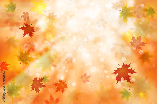Beautiful colorful autumn season blurred leaves on blurry bright yellow, orange and red bokeh background with light beams. Autumn season illustration with copyspace background.