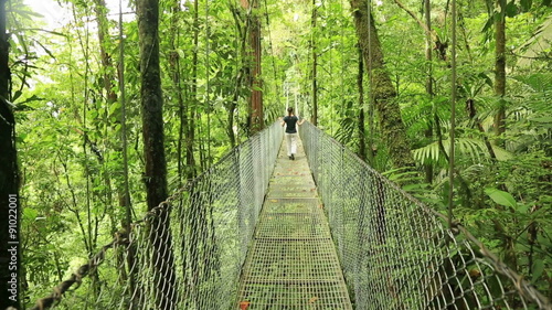 Woman walking on hanging bridge at natural rainforest park, Costa Rica